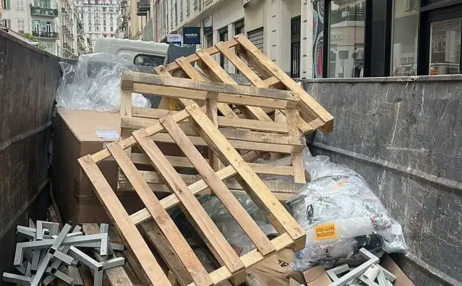 Benne chargée de palettes et d’encombrants dans une rue